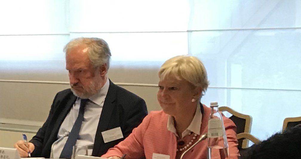 Ein Mann und eine Frau sitzen in einem Konferenzraum an einem Tisch.