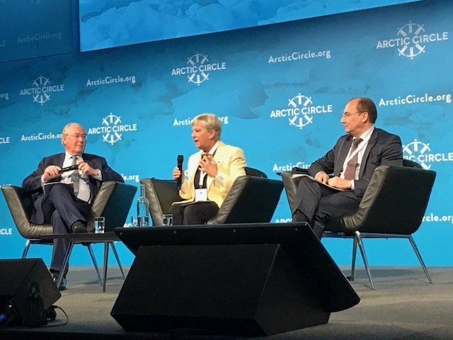 Drei Menschen sitzen auf Stühlen auf einer Bühne vor einer Wand mit der Aufschrift „Polarkreis“