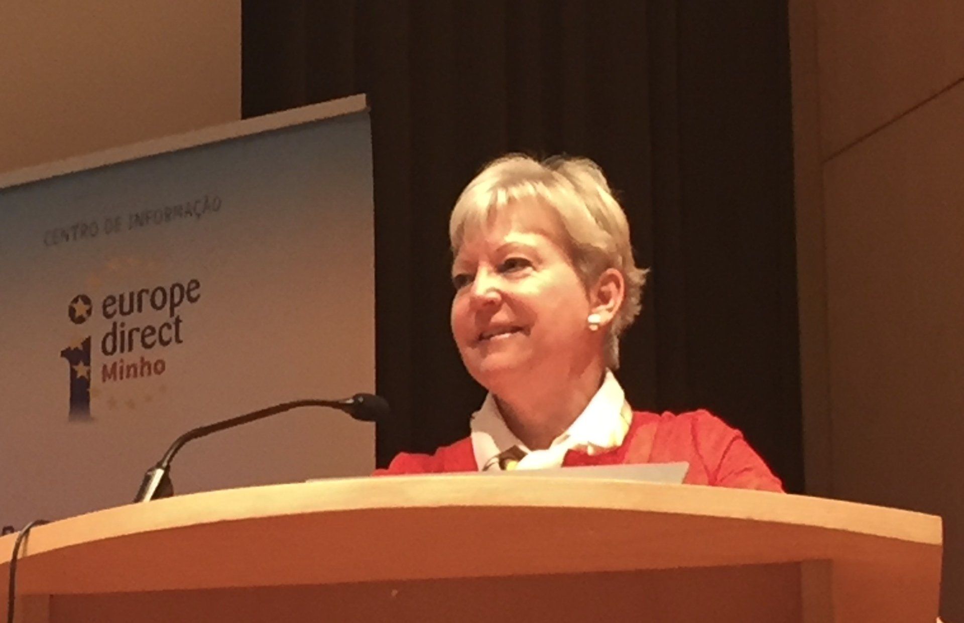 Eine Frau hält eine Rede an einem Podium mit der Aufschrift „Europe Direct“