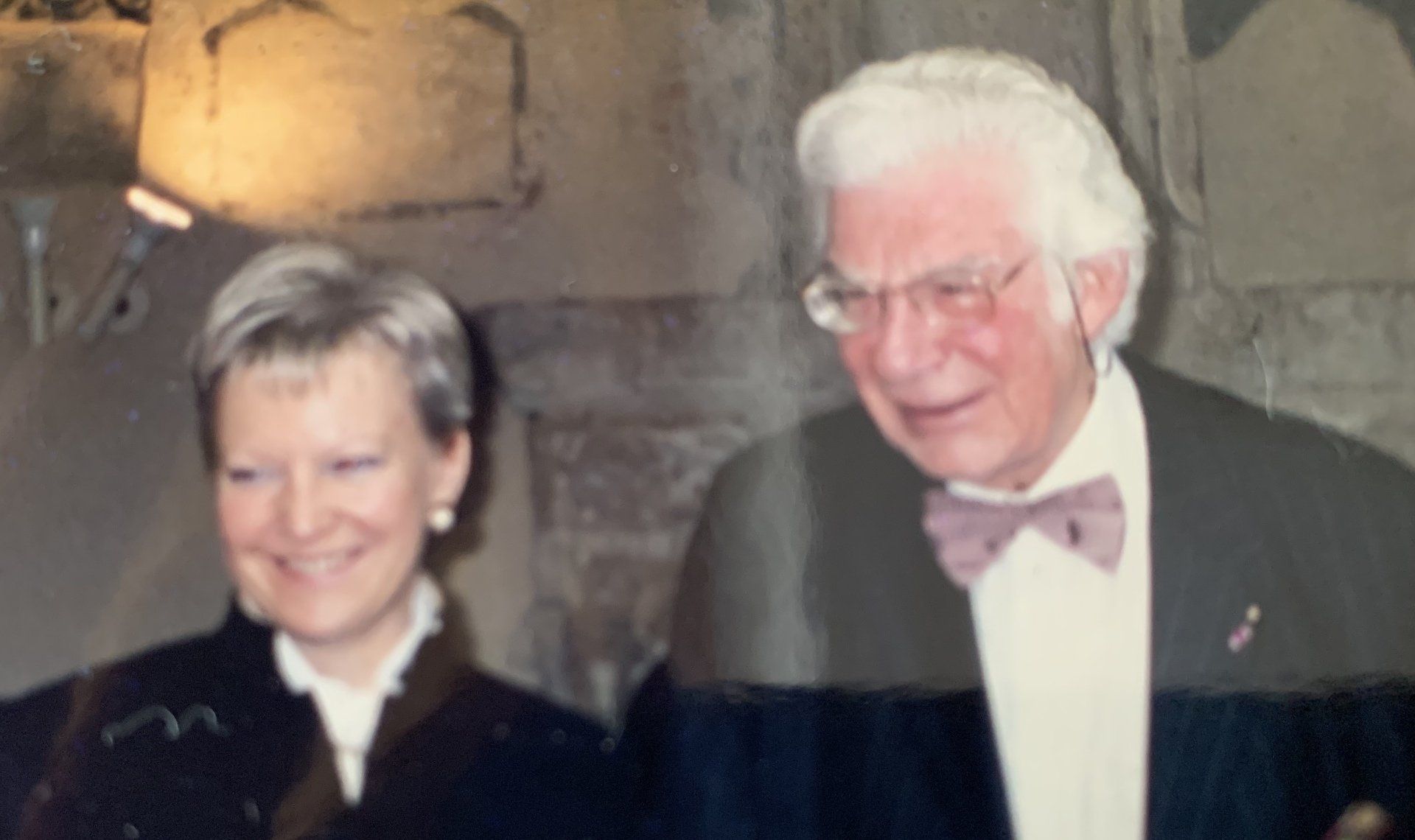 Ein Mann im Smoking und mit Fliege steht neben einer Frau