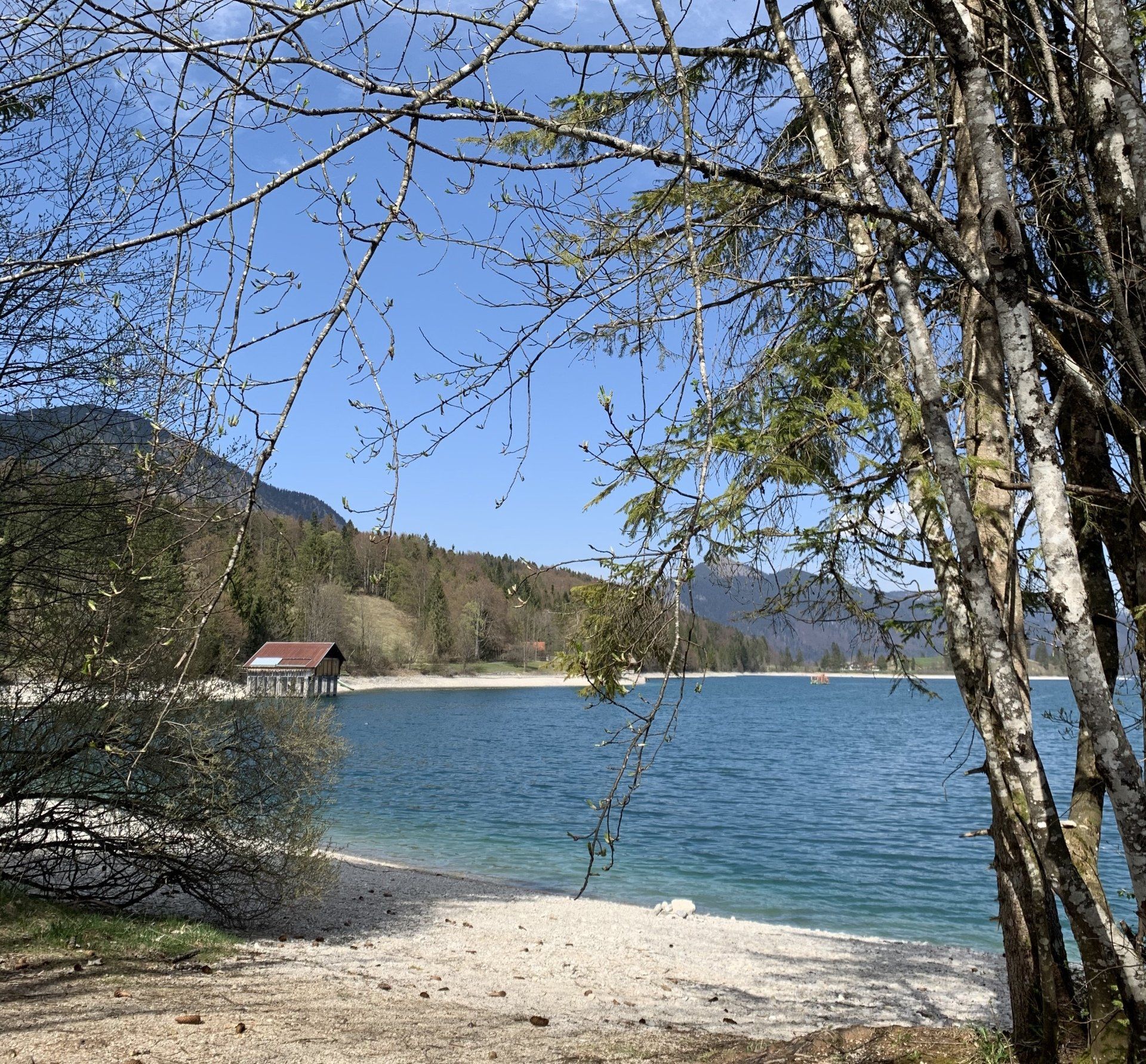 Ein kleines Haus liegt am Ufer eines Sees