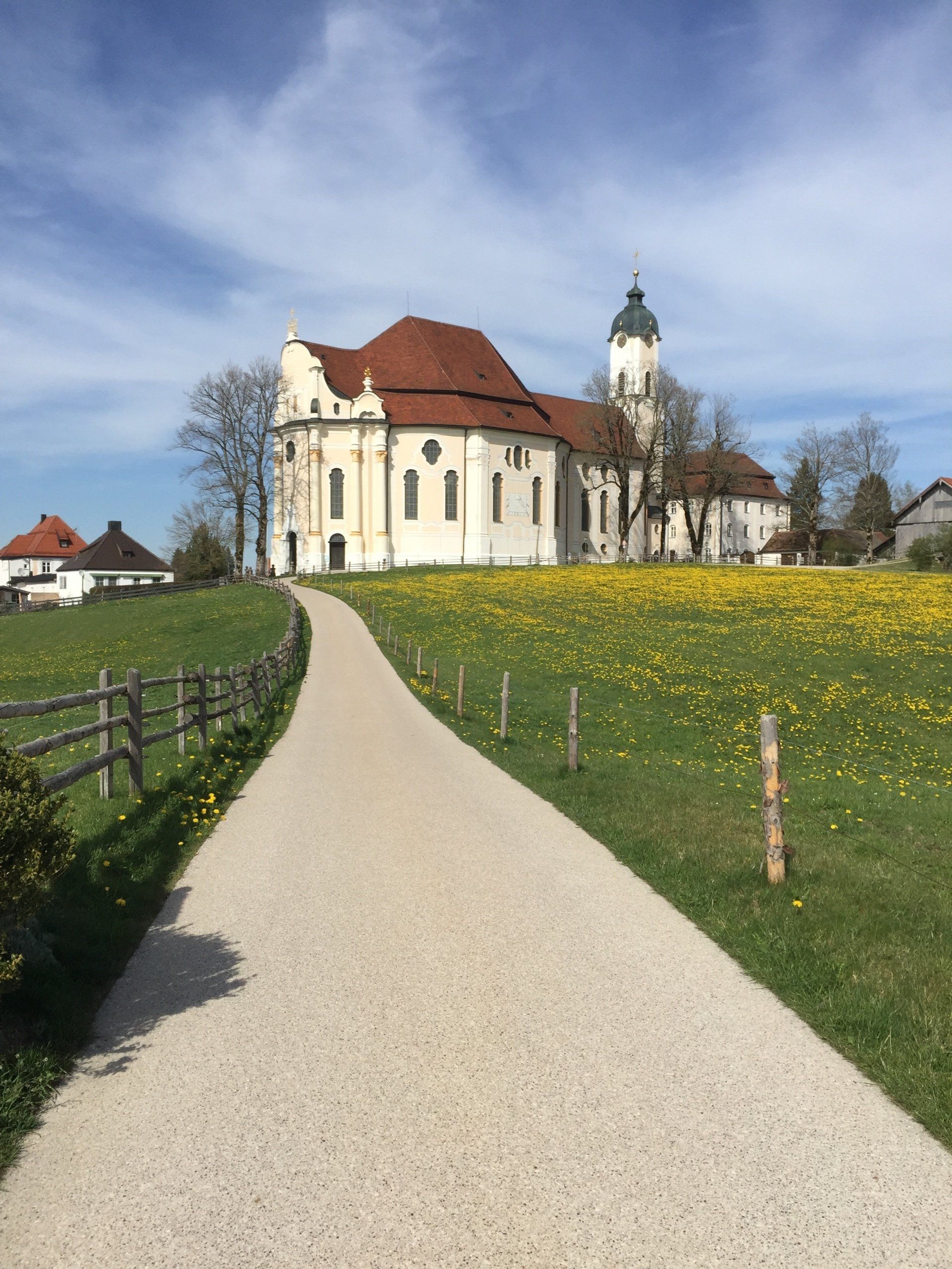 Ein Weg, der zu einem großen weißen Gebäude mit einem roten Dach führt