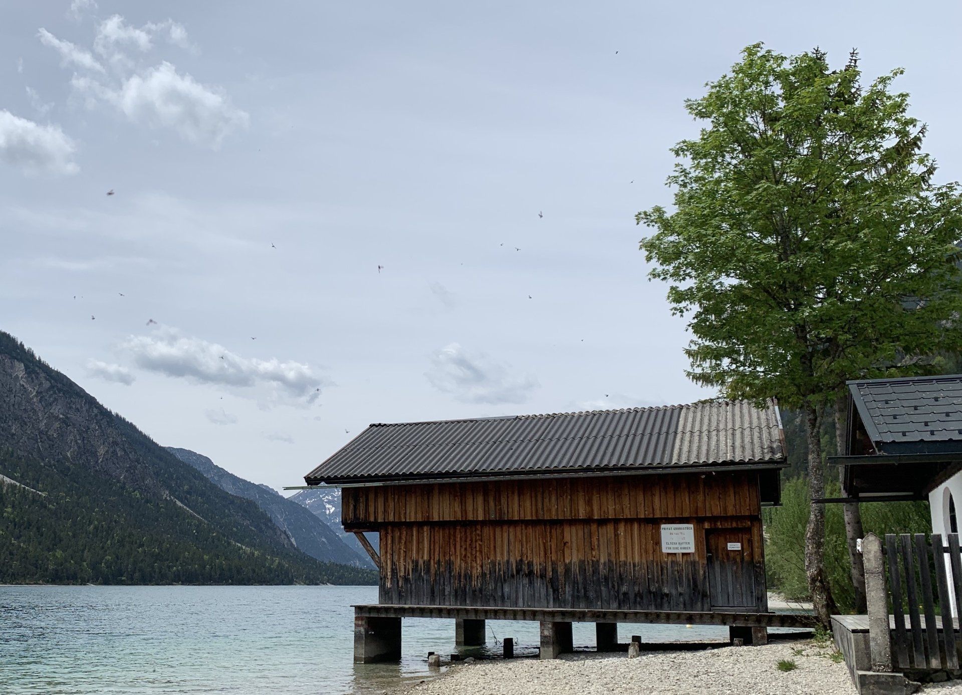 Ein kleines Holzhaus steht am Ufer eines Sees.