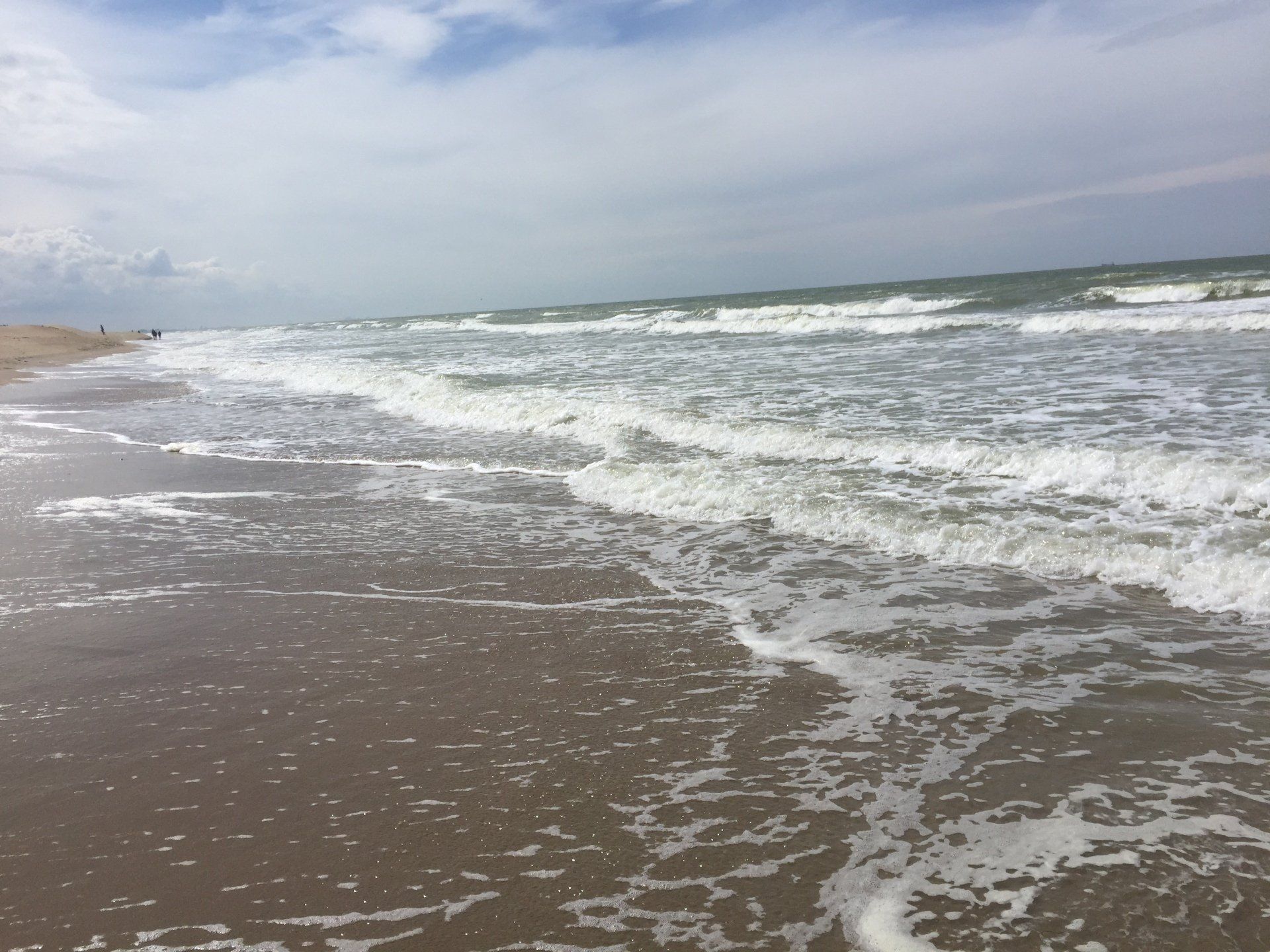 Ein Strand mit Wellen an einem bewölkten Tag