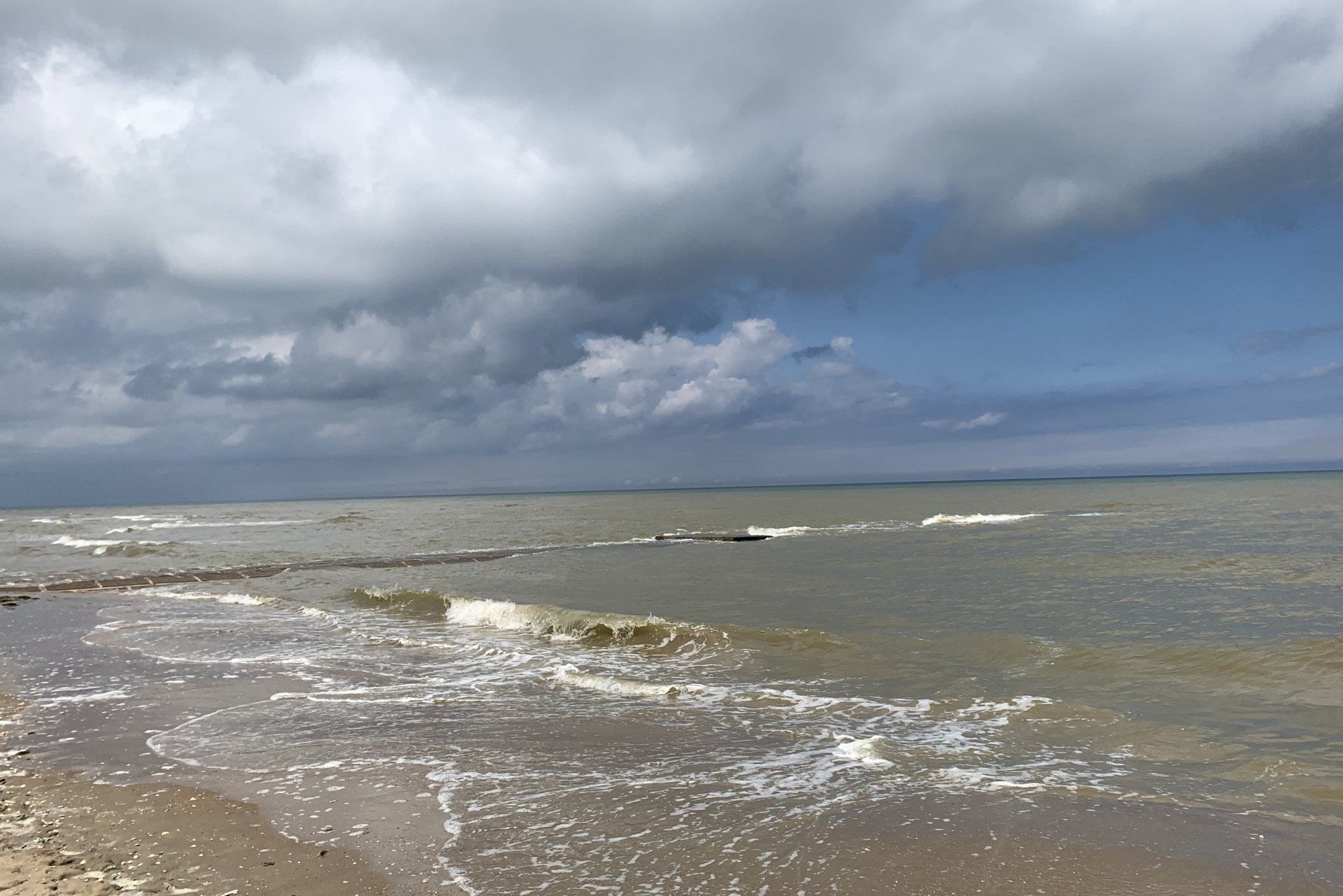Ein Strand mit Wellen an einem bewölkten Tag