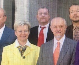 Eine Gruppe von Menschen in Anzug und Krawatte posiert für ein Foto.