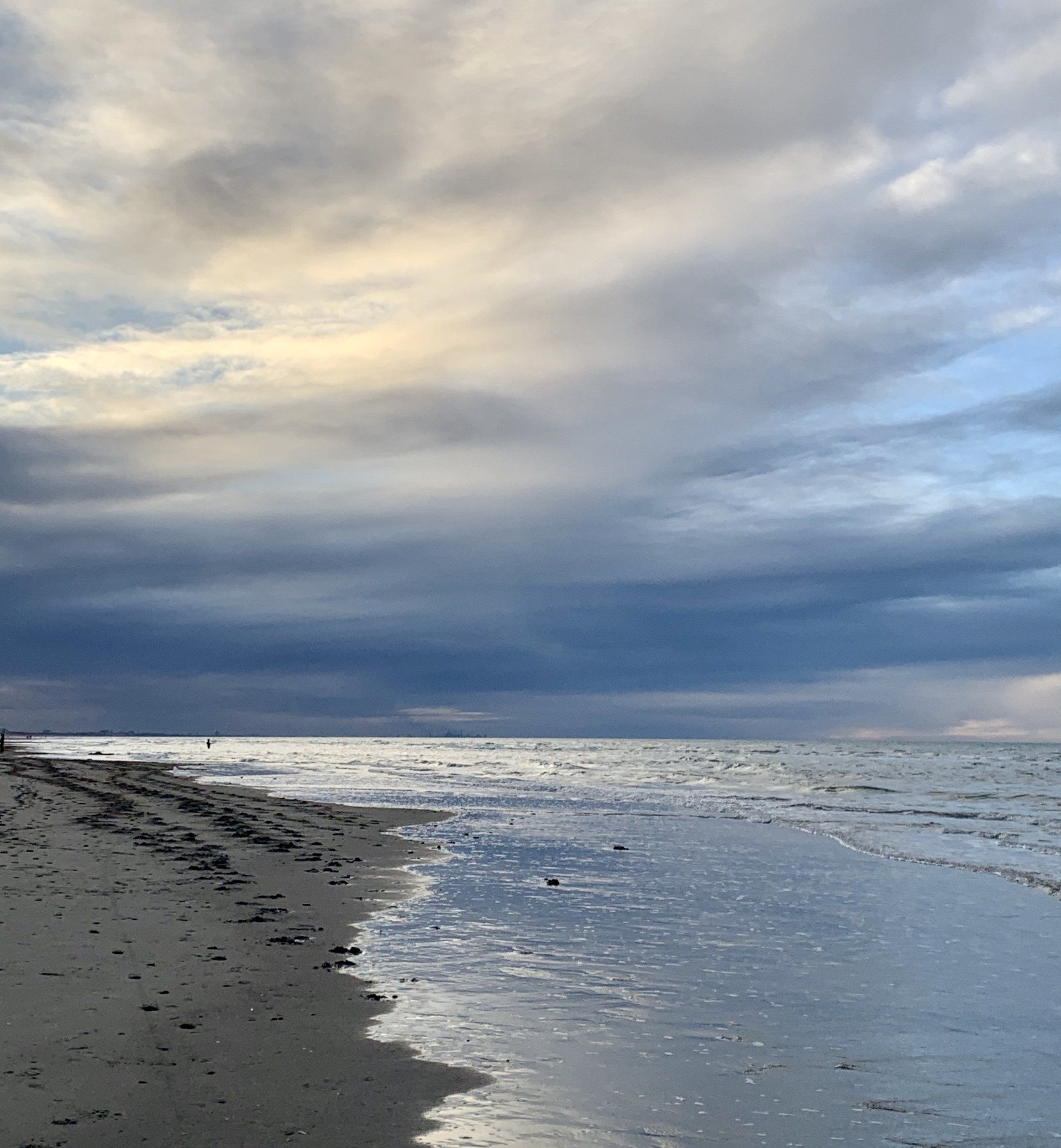 Ein Strand mit bewölktem Himmel und einem Gewässer