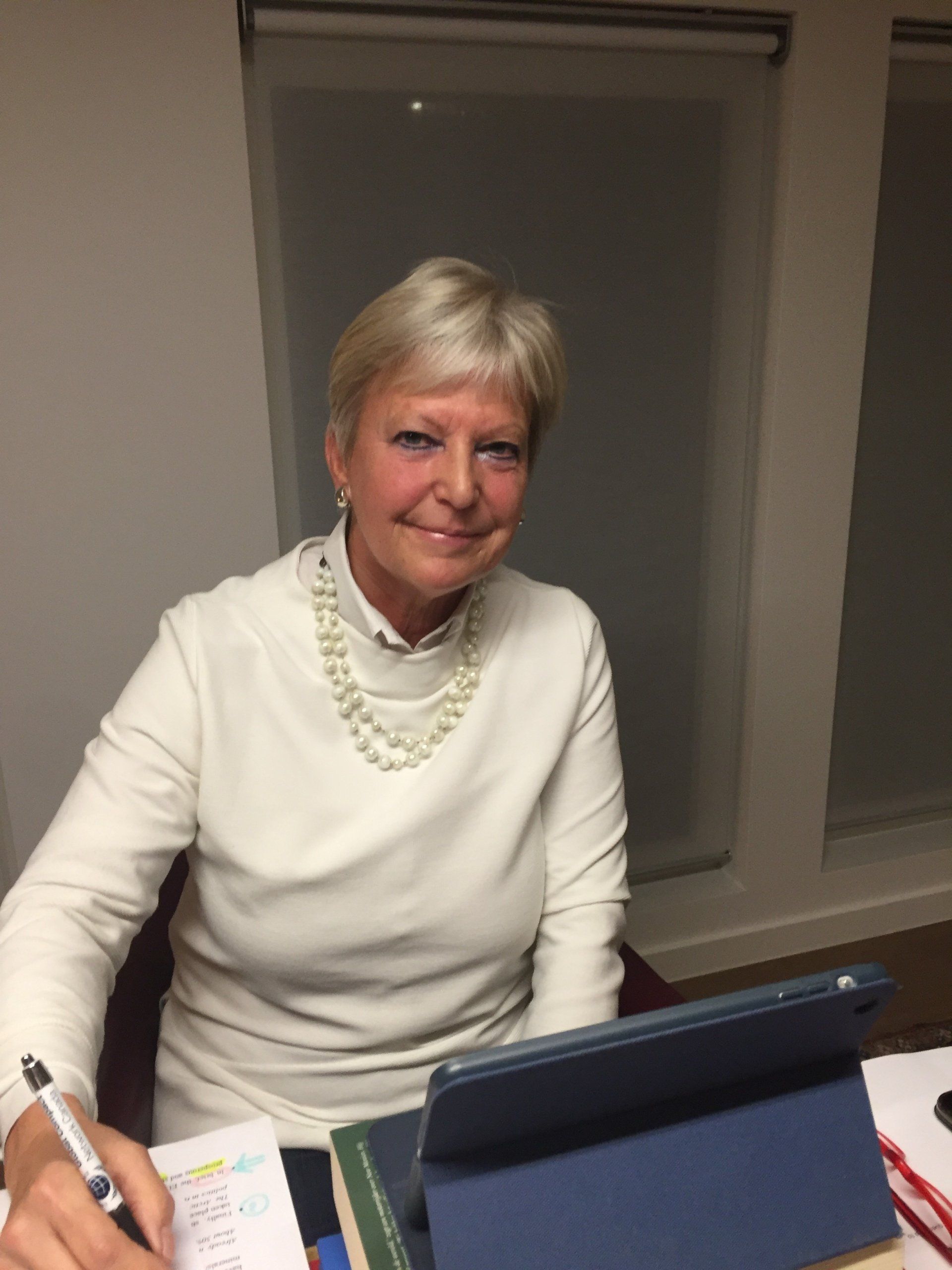 Eine Frau sitzt mit einem Tablet und einem Stift an einem Schreibtisch