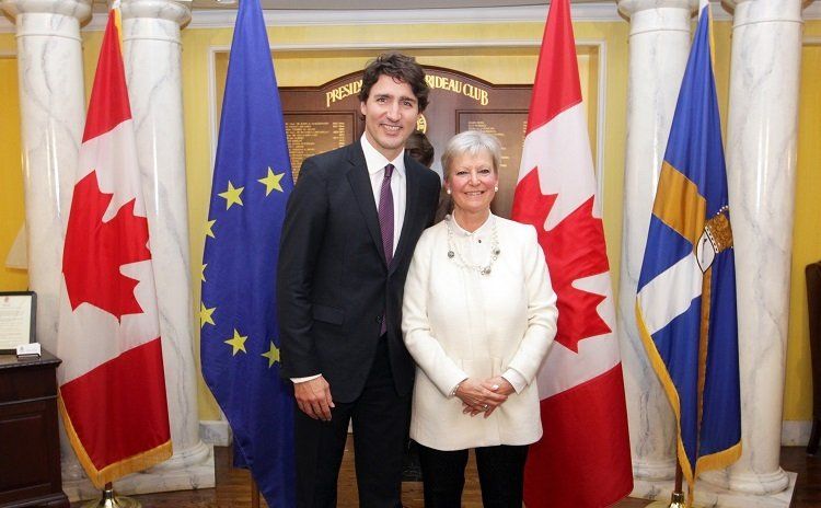 Ein Mann und eine Frau posieren vor Flaggen für ein Foto.