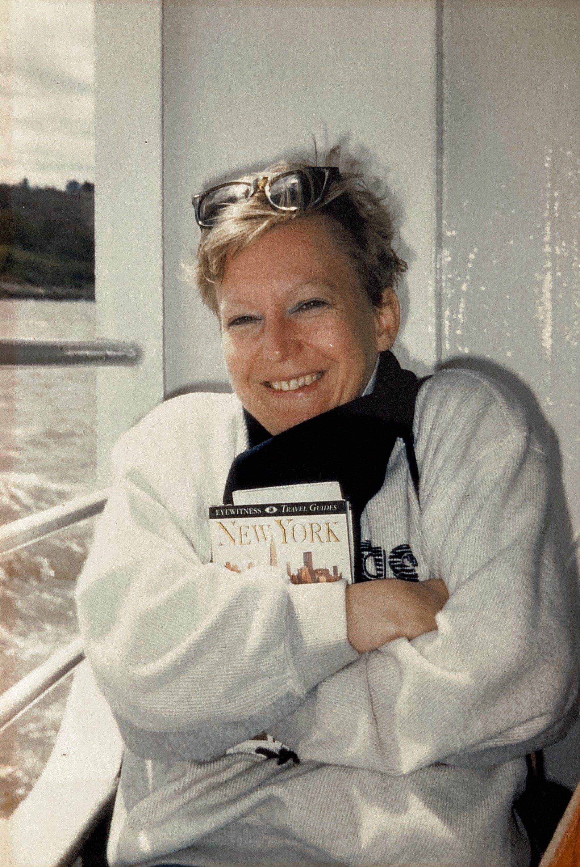 Eine Frau hält ein Buch mit der Aufschrift „New York“