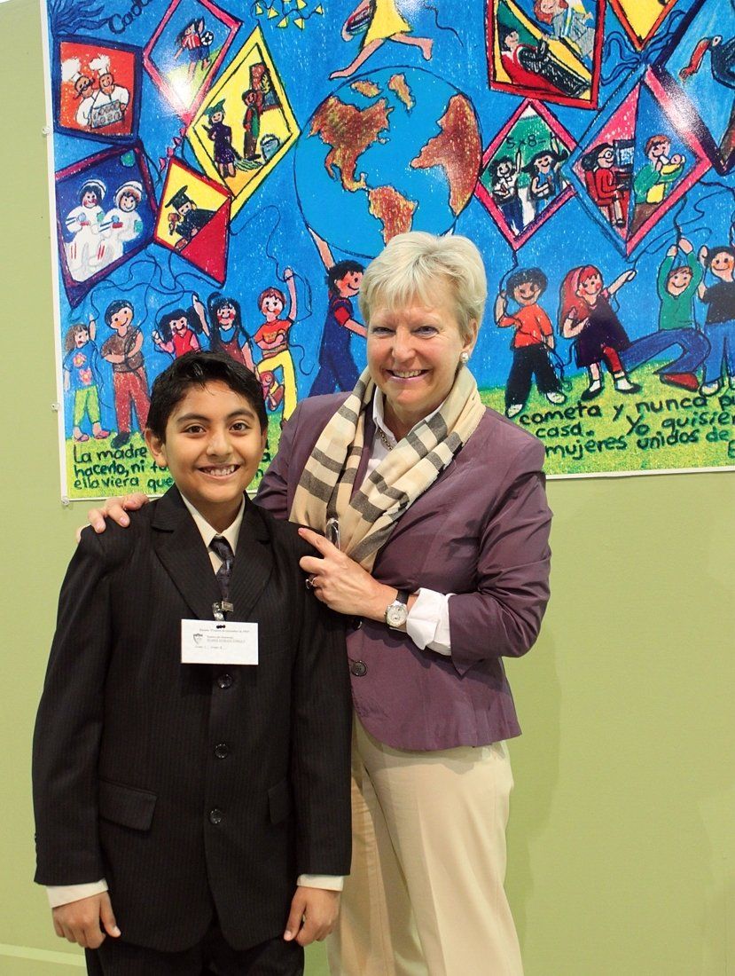 Eine Frau und ein Junge posieren für ein Foto vor einem Gemälde