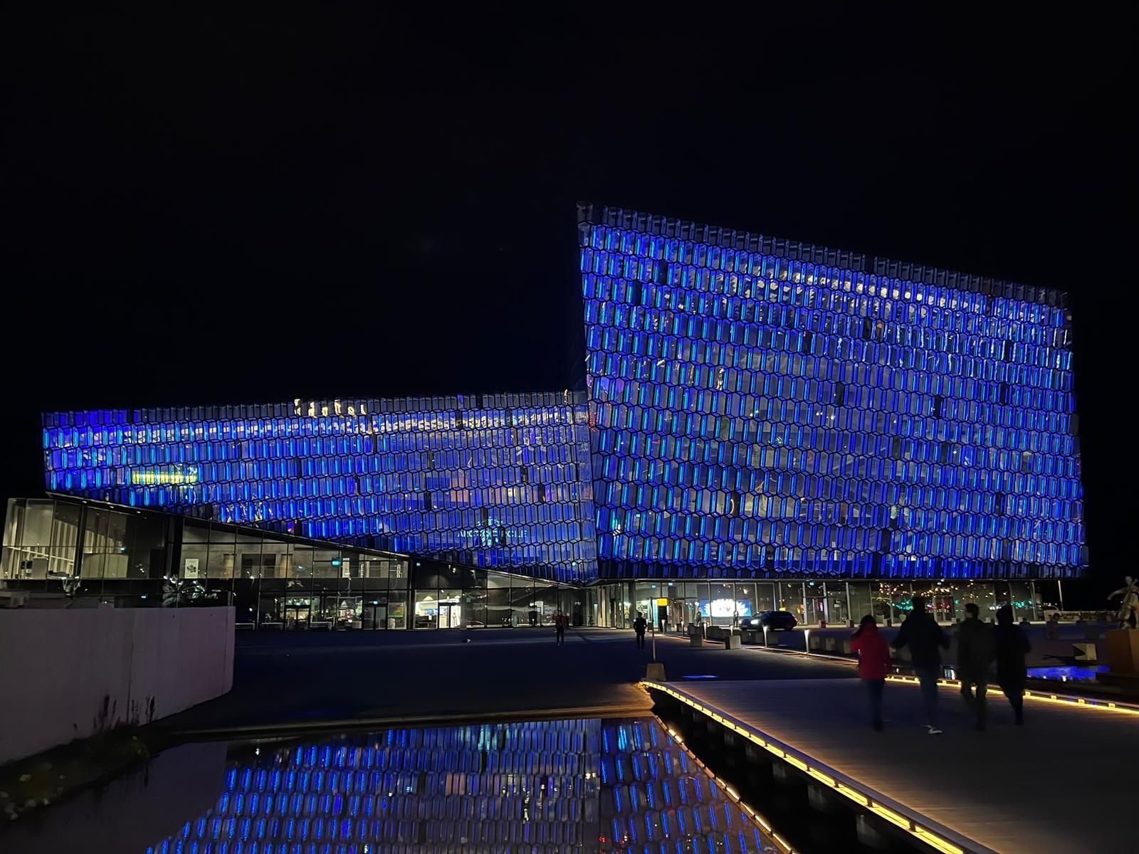 Ein großes Gebäude wird nachts mit blauen Lichtern beleuchtet.