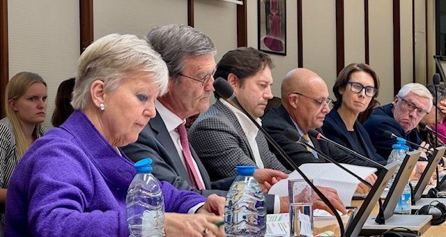 Eine Gruppe von Menschen sitzt an einem Tisch in einem Konferenzraum.