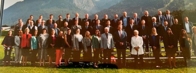 Eine große Gruppe von Menschen posiert vor einem Berg für ein Foto.