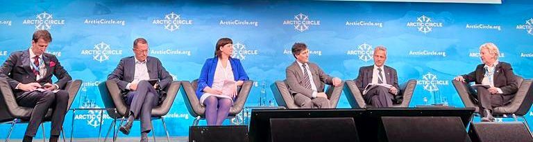 Eine Gruppe von Leuten sitzt an einem Tisch vor einem Mikrofon.