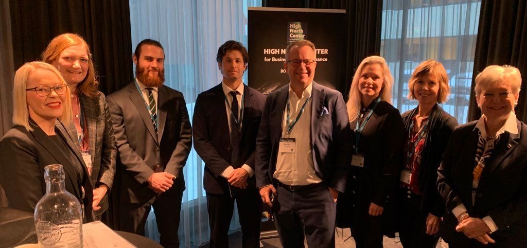 Eine Gruppe von Menschen in Anzug und Krawatte steht nebeneinander in einem Raum.