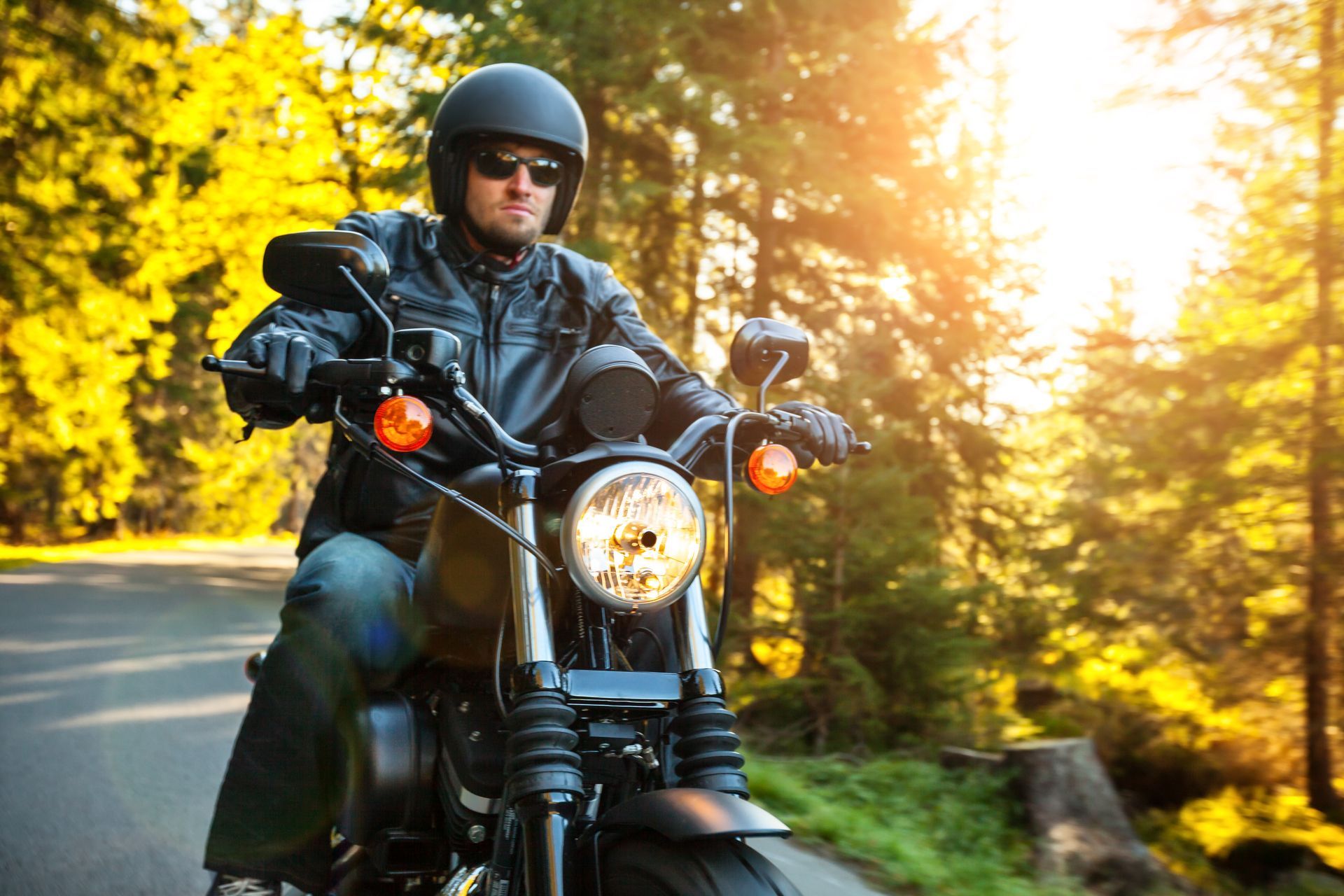 A man is riding a motorcycle down a road.