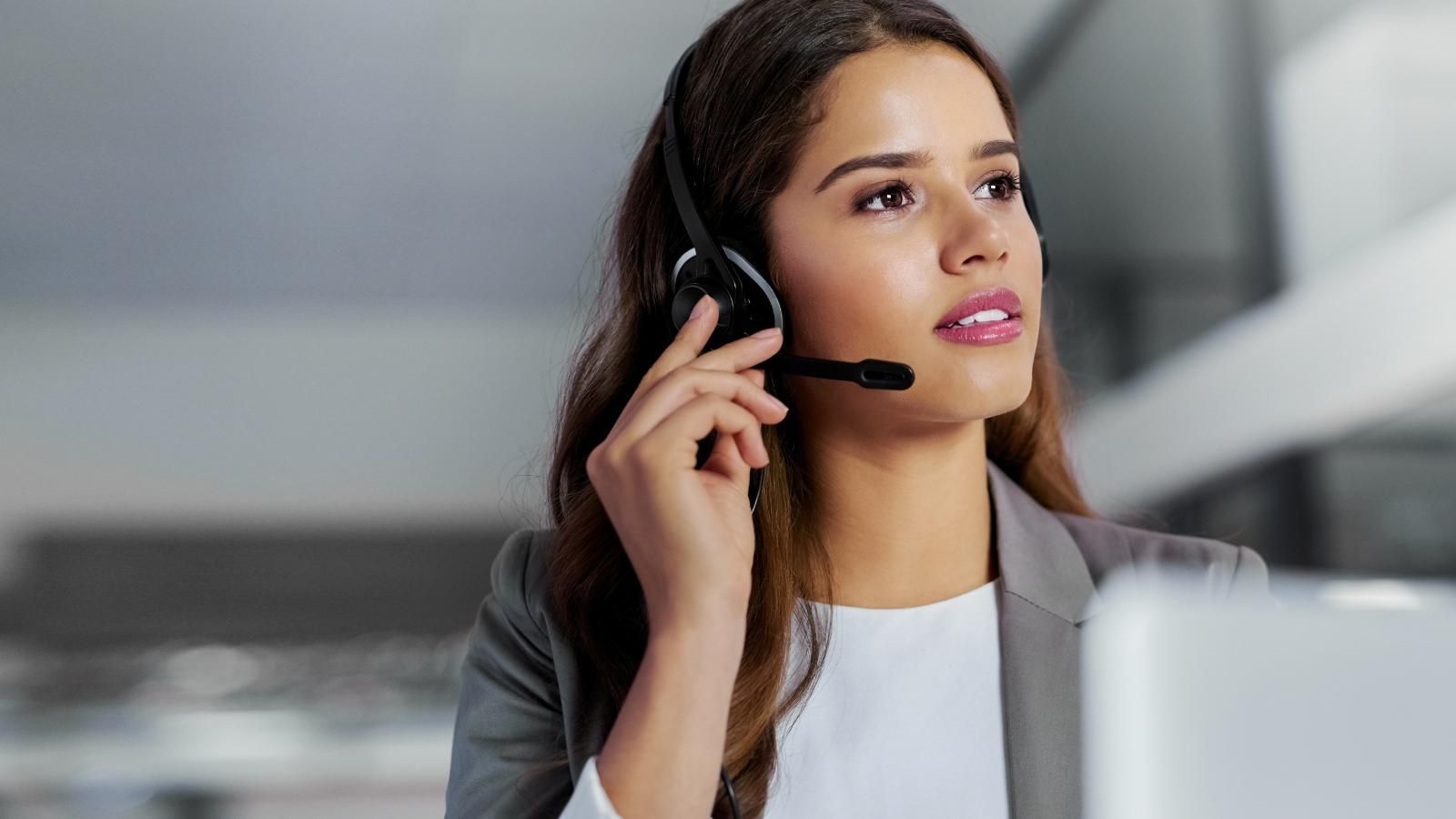 A virtual receptionist is wearing a headset while scheduling an appointment for a patient.