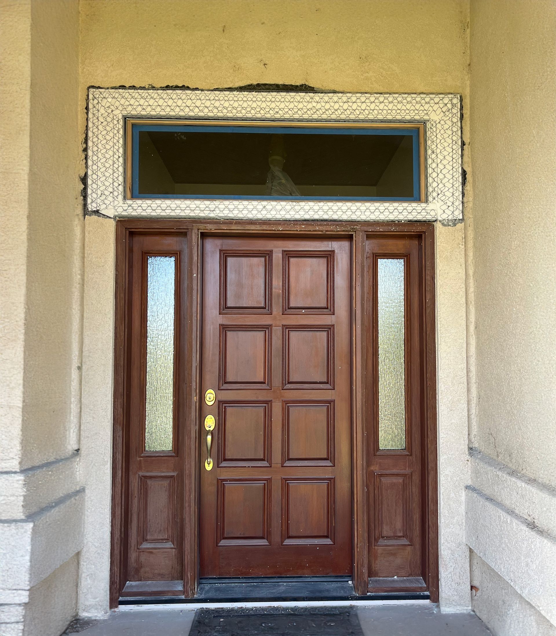 Large stucco patch repair around a new window above a front door in Reno, Nevada.