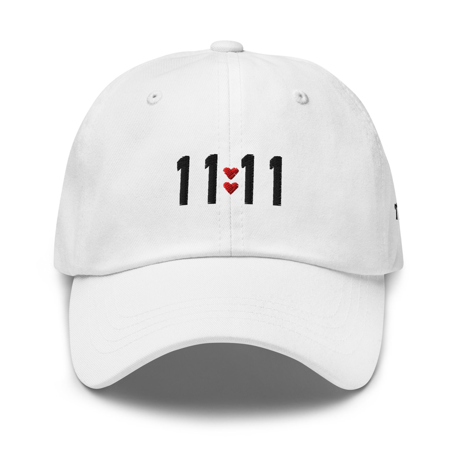 White dad hat embroidered with “11:11” and small red hearts on the front