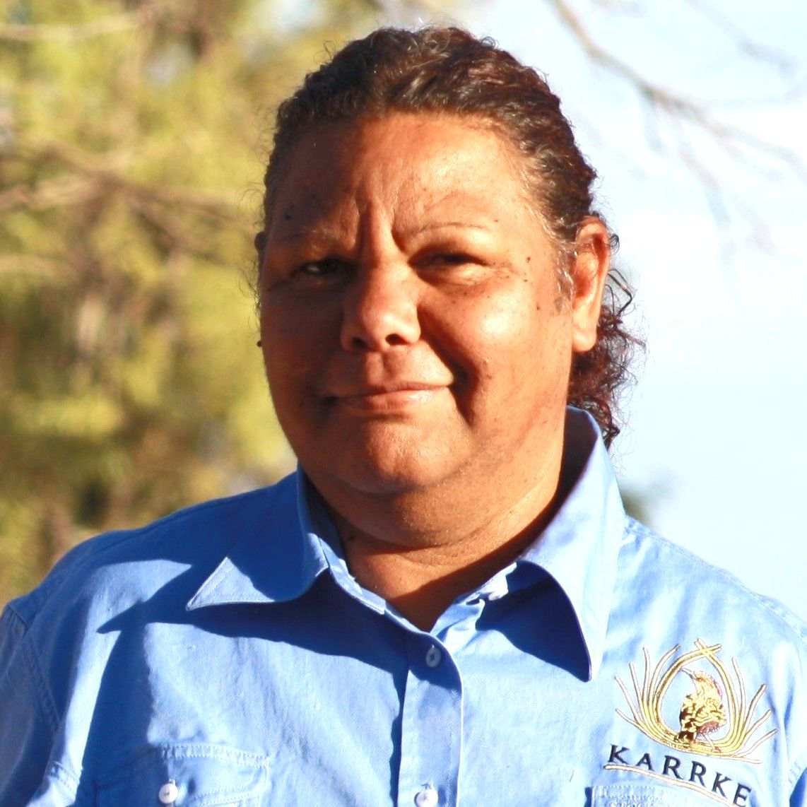A woman wearing a blue shirt that says karrke on it