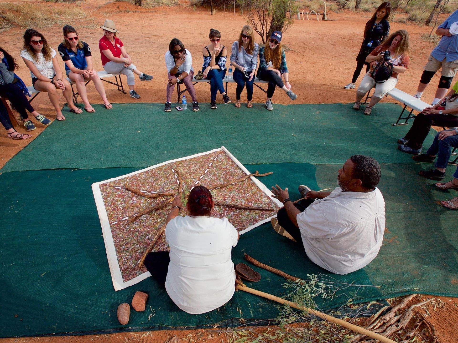 A group of people are sitting around a man sitting on the ground
