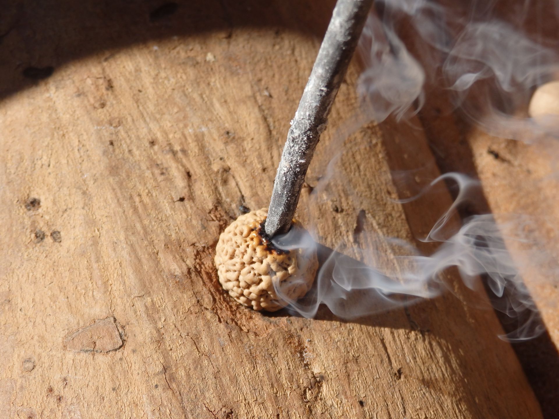 Smoke is coming out of a hole in a piece of wood