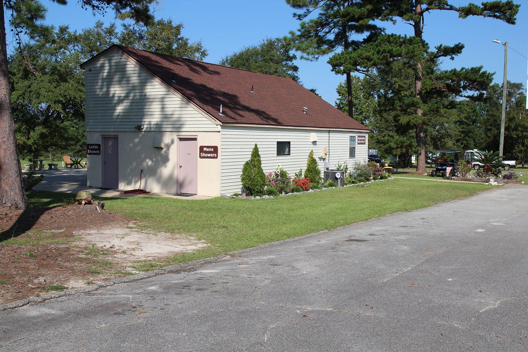 A small white house with a brown roof and a pink door