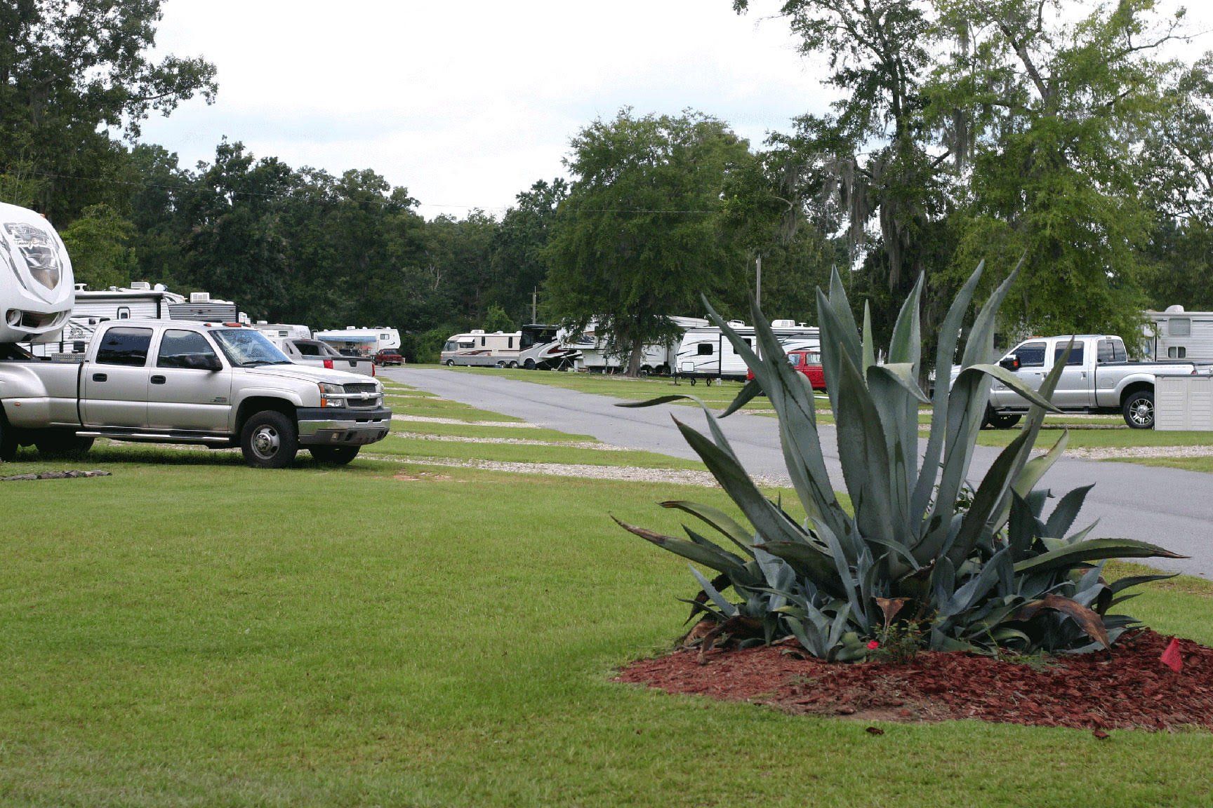 A white truck is parked in a grassy field