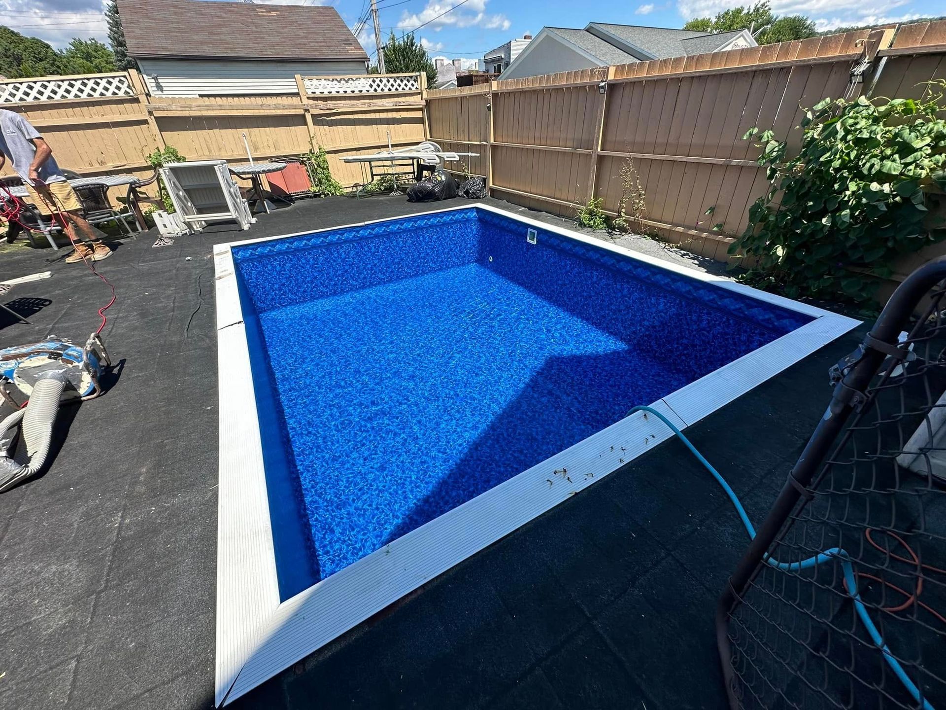Rectangular in-ground swimming pool with blue tile interior. 