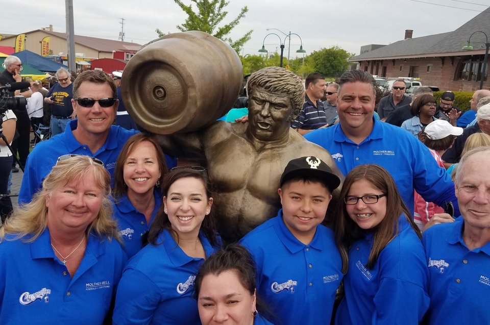 Molthen-Bell staff surround new statue of Reggie 