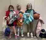 A group of children are standing next to each other holding basketballs.