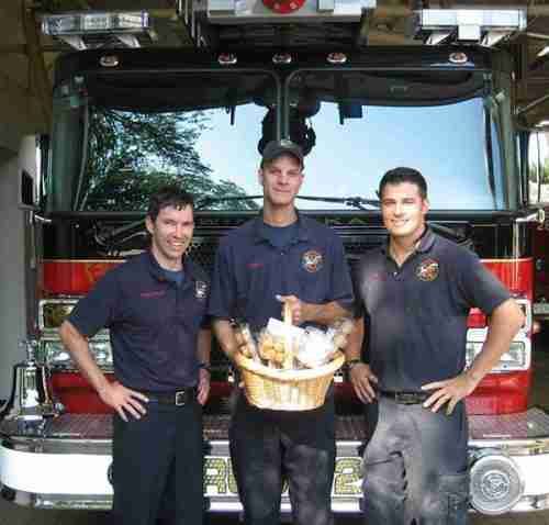 Three firefighters standing in front of a fire truck