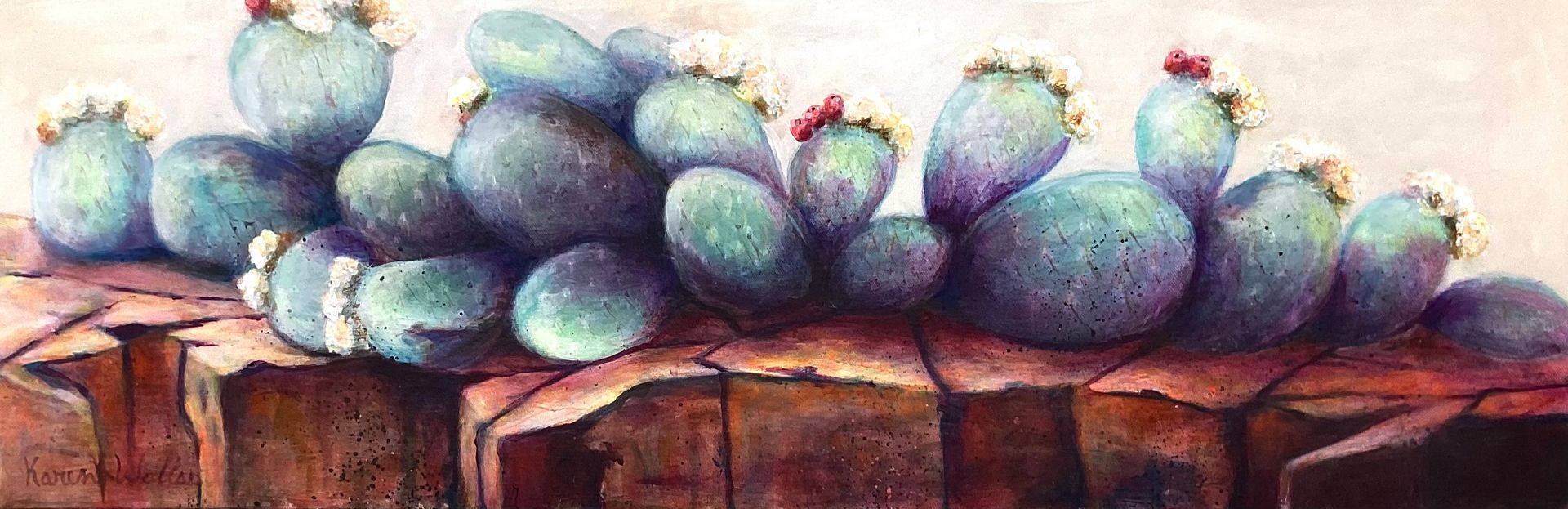 Blue-green prickly pear cacti with white and red flowers sit on a brown rocky surface, against a beige background.