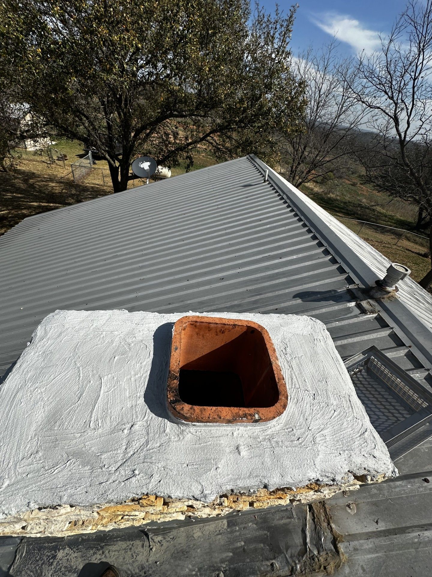 A chimney is sitting on top of a metal roof.