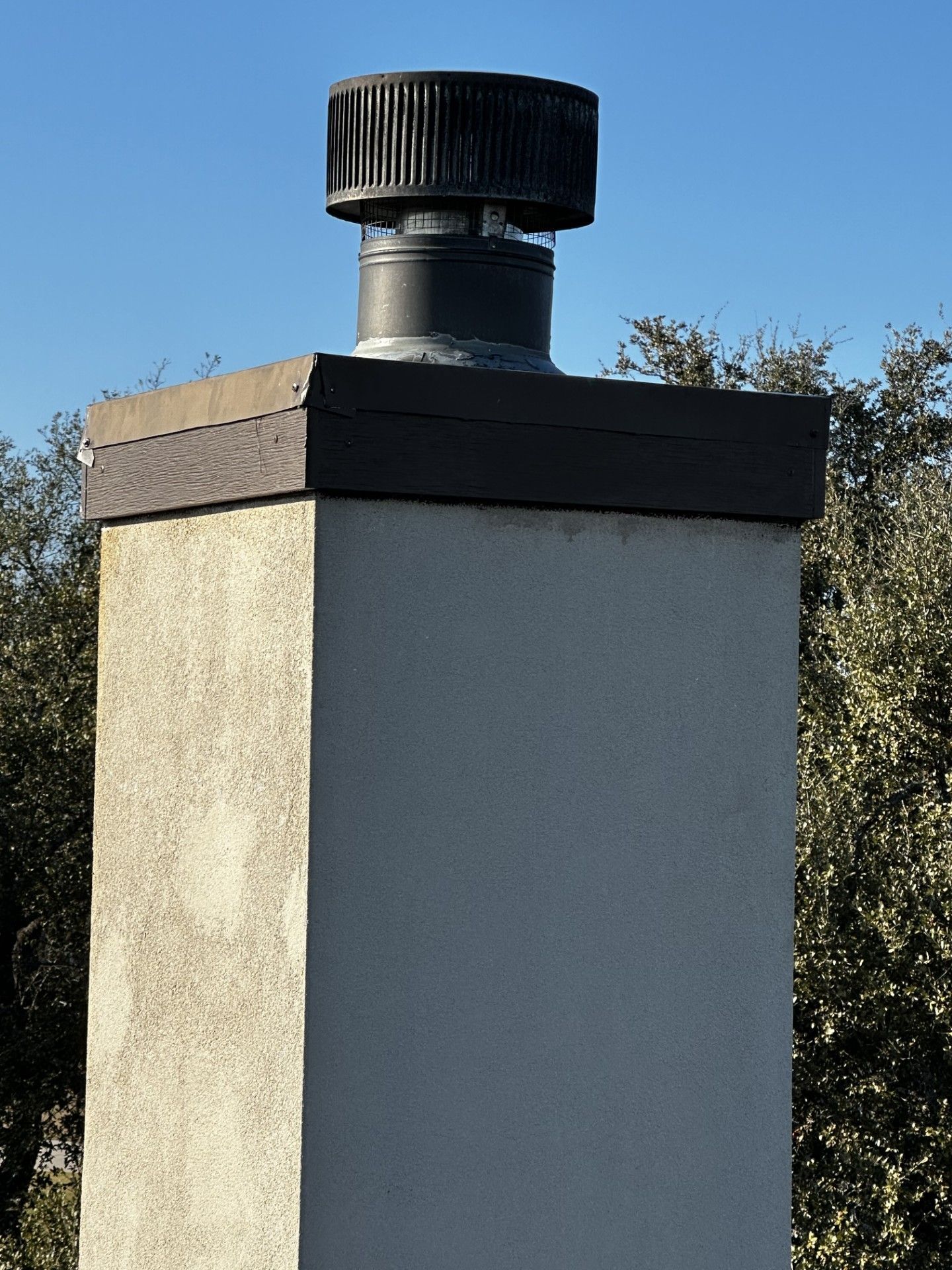 A chimney with a black cap on top of it