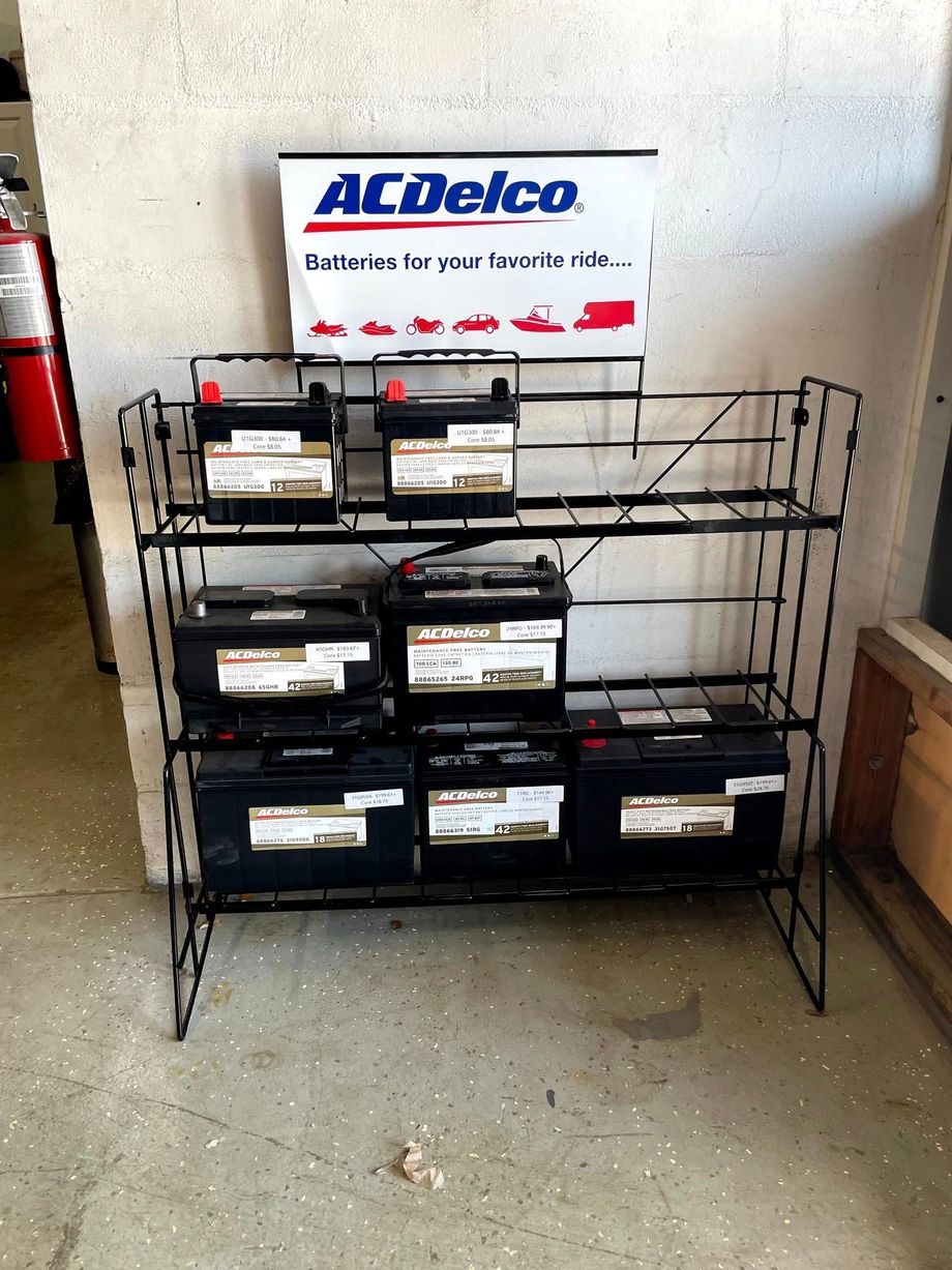 Stack of DEF fluid containers, pressure washer, and sign in a garage.