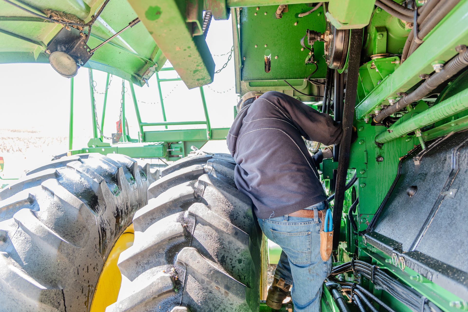 Man with arms crossed wearing a hard hat and navy blue shirt, smiling.