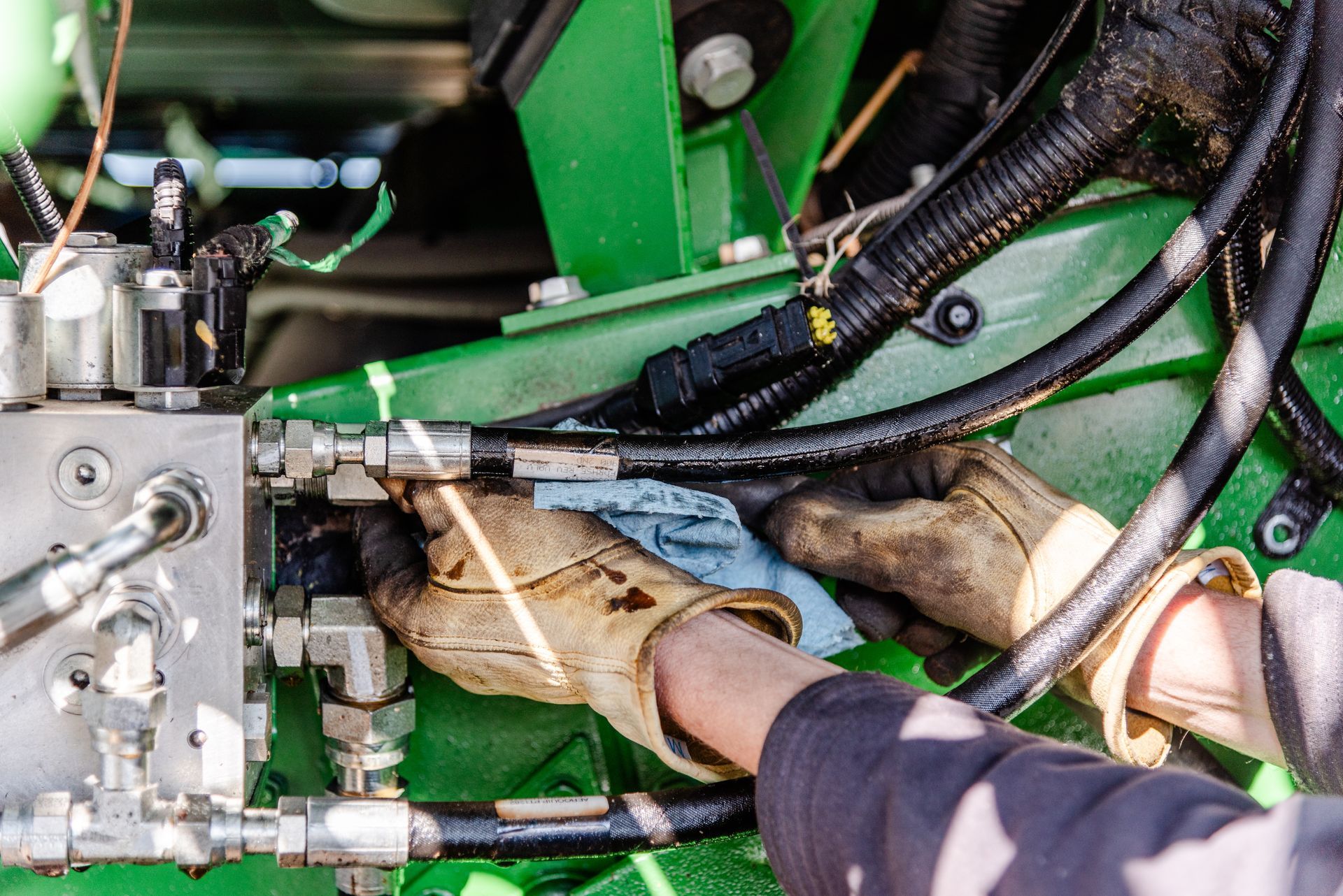 Orange and beige JLG scissor lift parked in front of a repair shop.
