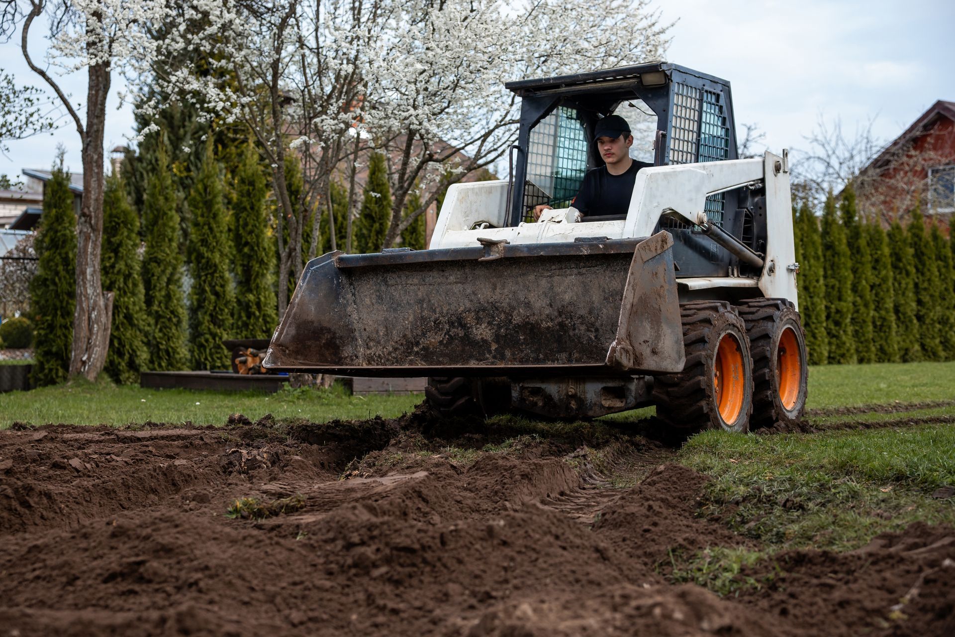 Man with crossed arms wearing a hard hat and blue shirt.