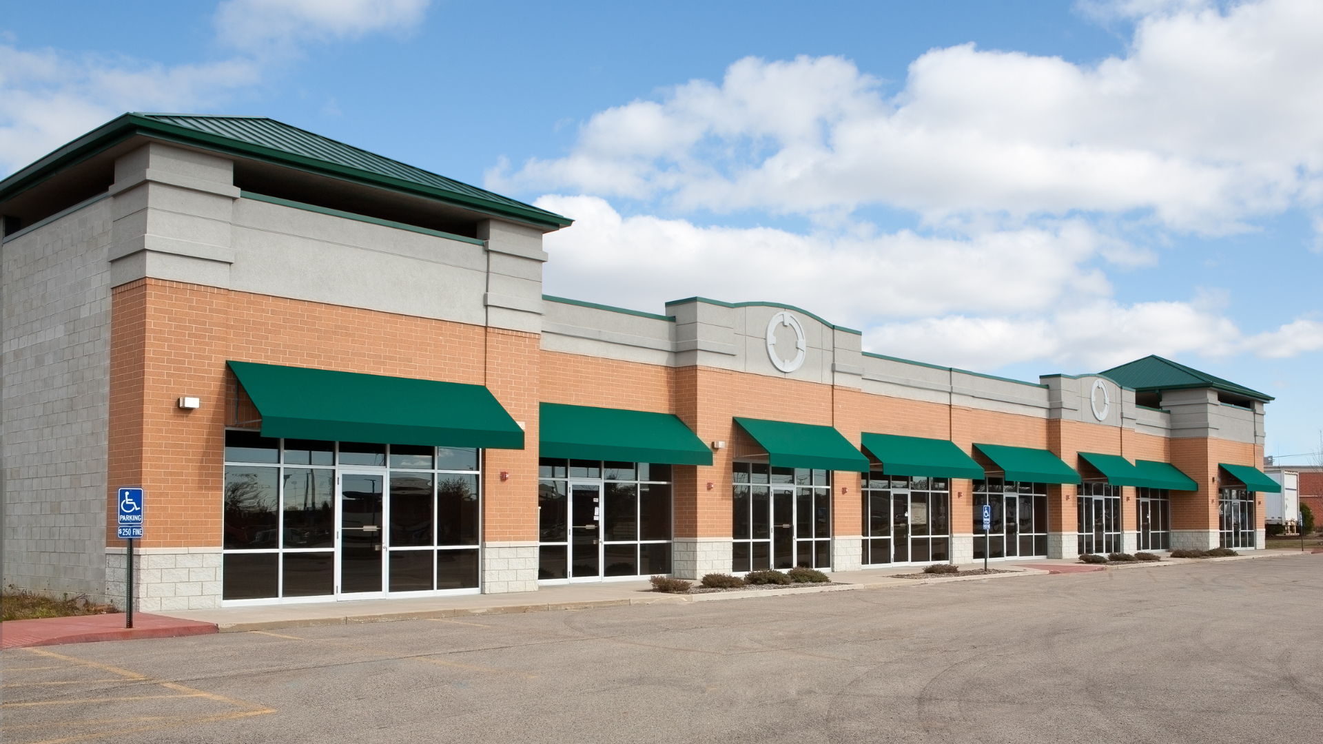 A brick building with green awnings on the windows