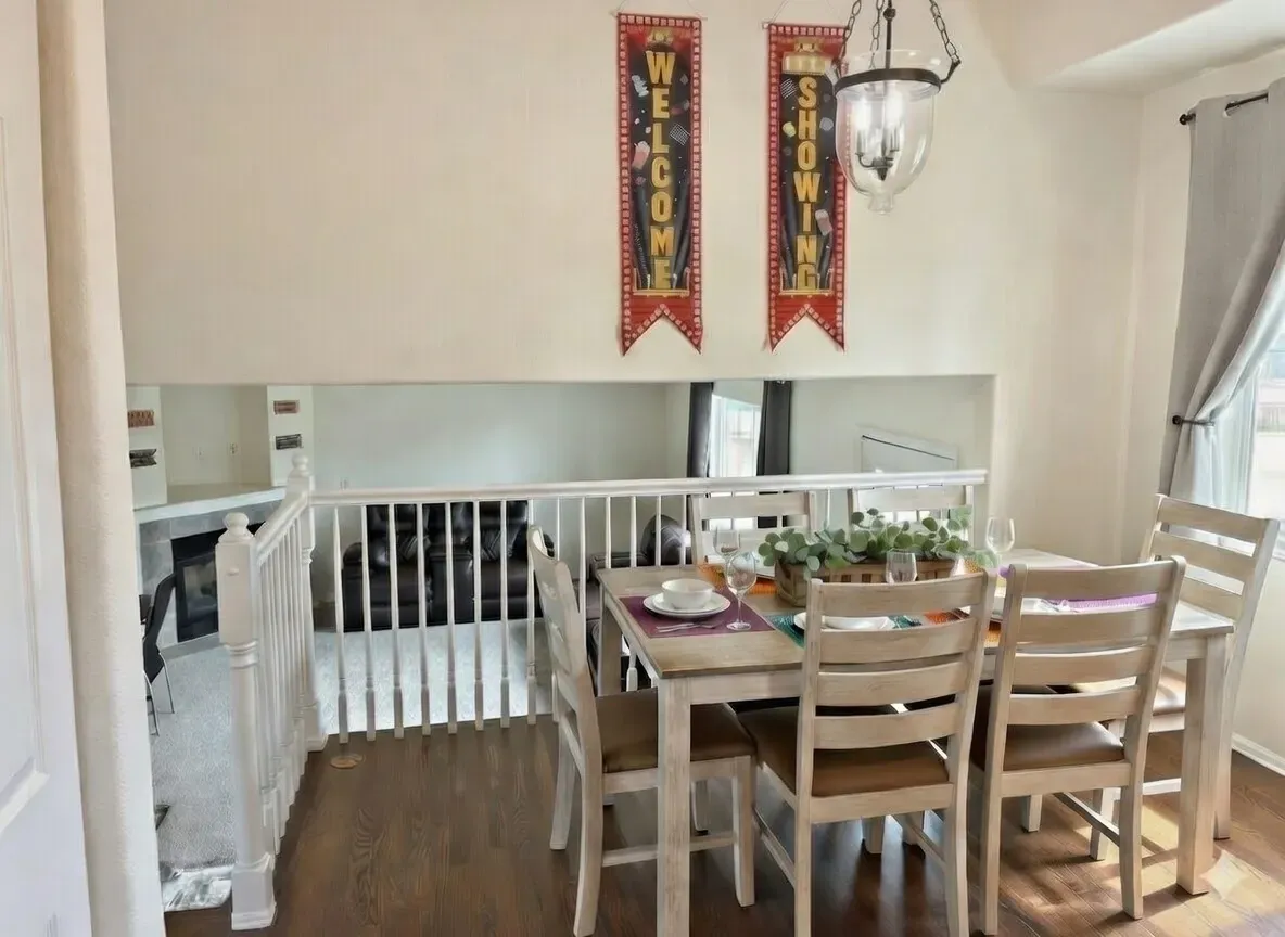 Open-concept dining area in Fountain, CO with seating for 6 featuring a balcony overlook to the living room—perfect for team strategy sessions and group celebrations near Colorado Springs.