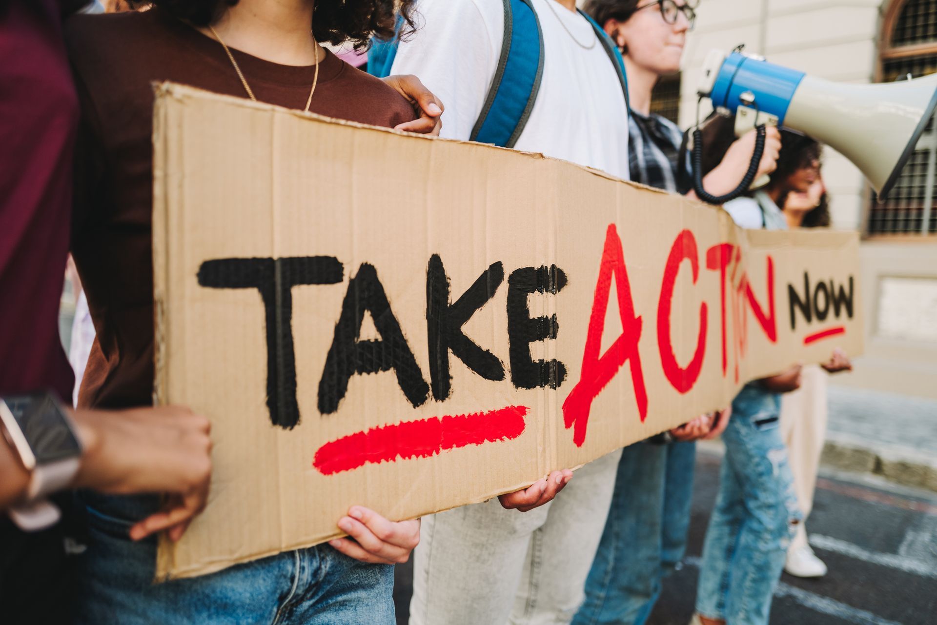 Photo of protesters holding a sign saying 