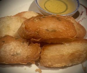 A close up of a plate of food with a bowl of dipping sauce.