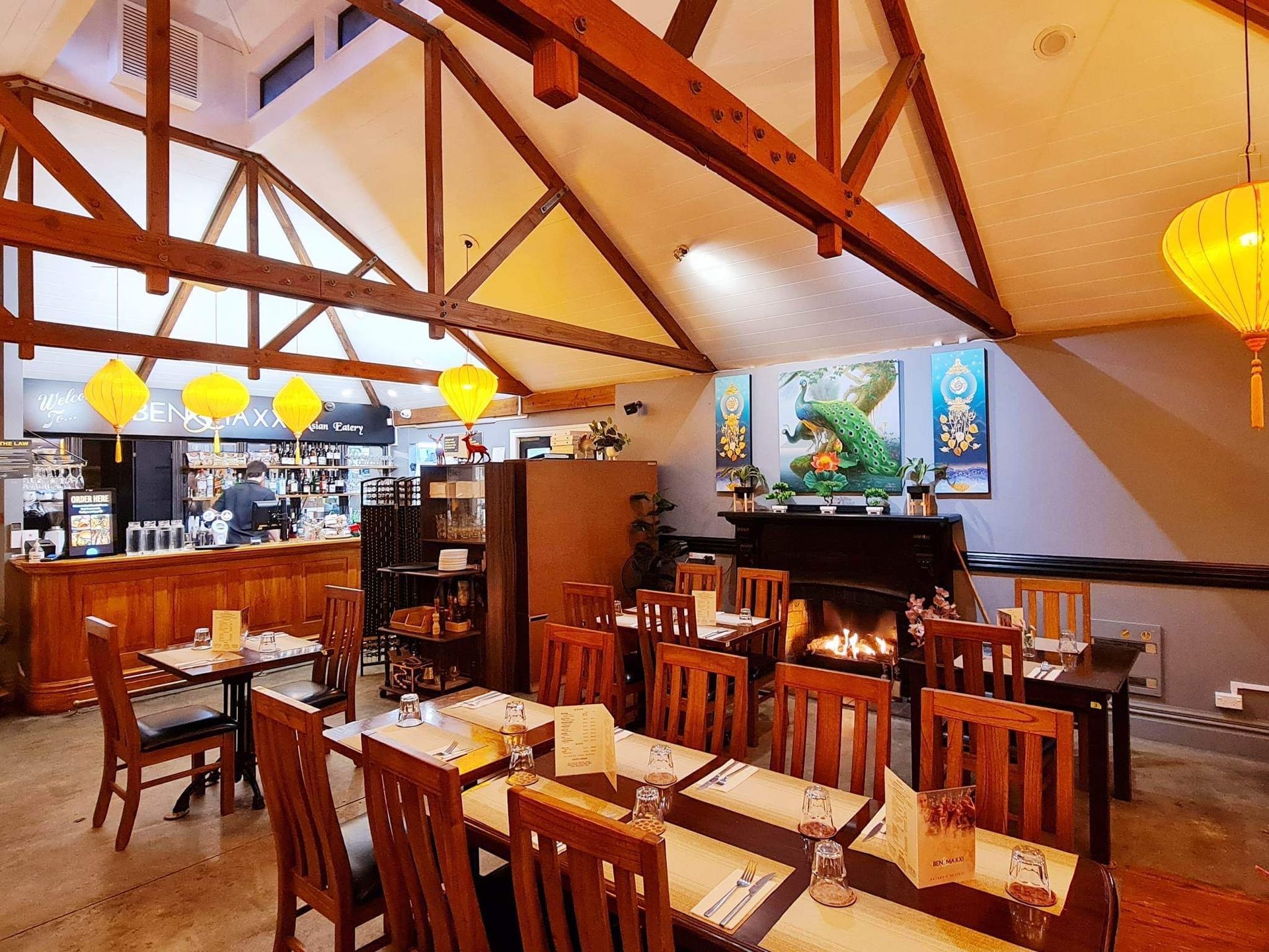 A restaurant with tables and chairs and a fireplace