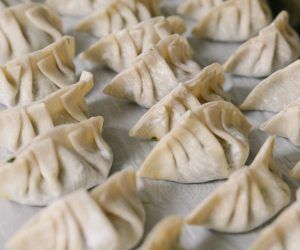 A bunch of dumplings are sitting on a table.