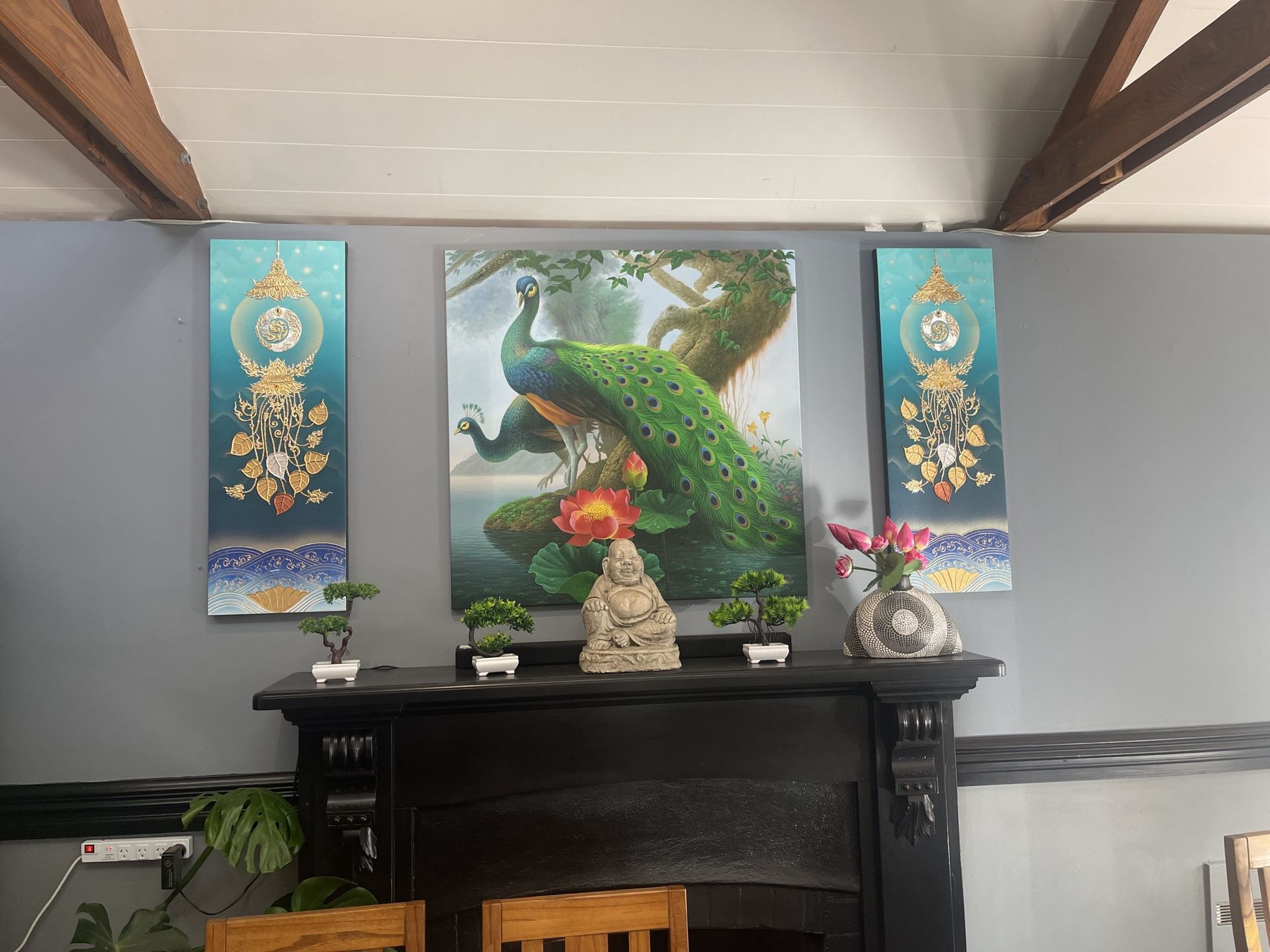There is a painting of a peacock on the wall above the fireplace.