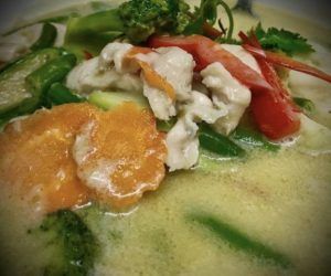 A close up of a bowl of soup with meat and vegetables.