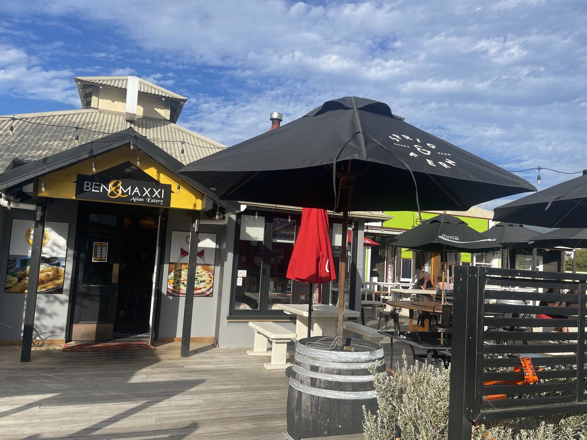 A restaurant with a lot of umbrellas in front of it.