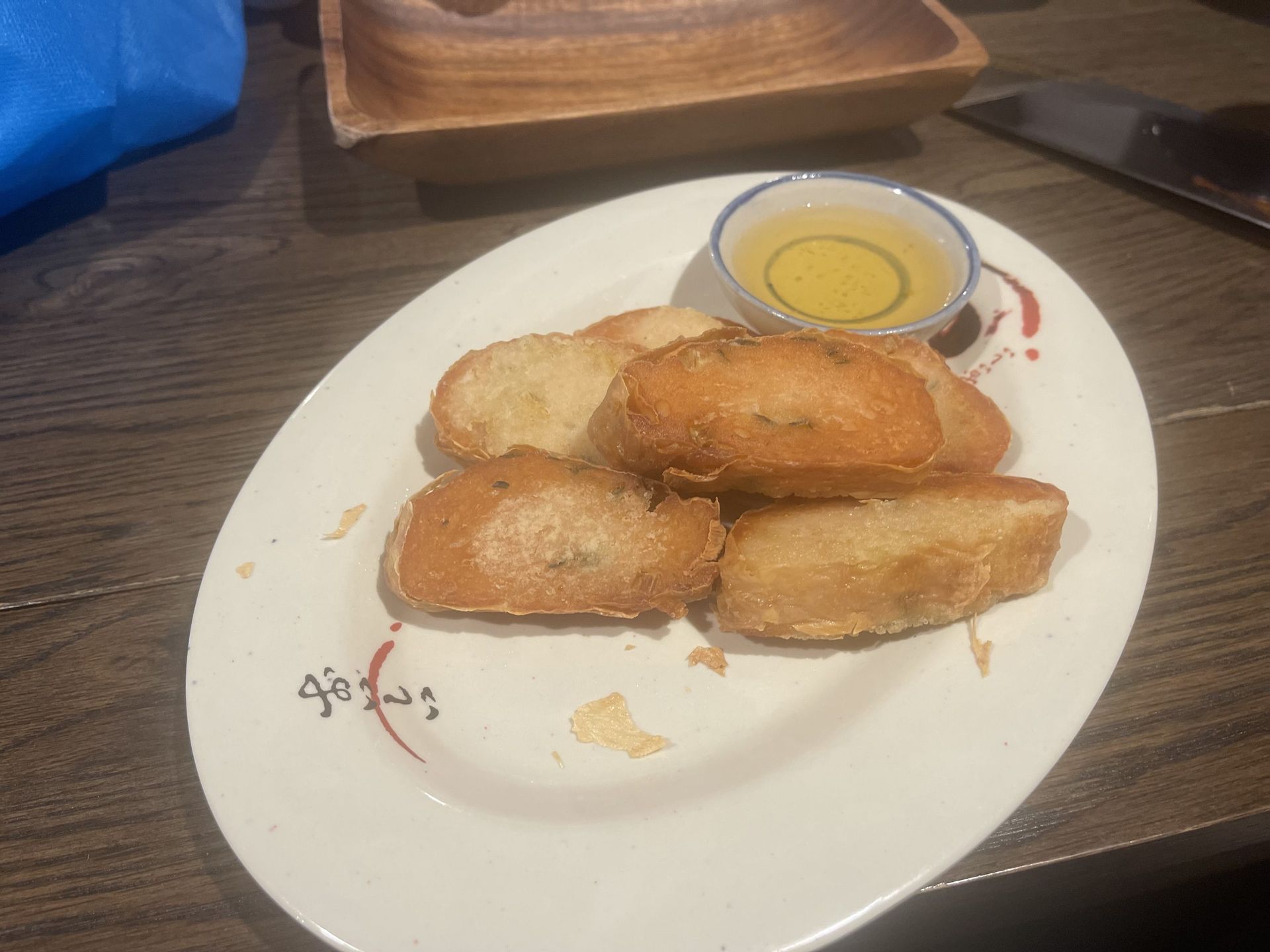 A white plate topped with bread and a small bowl of oil